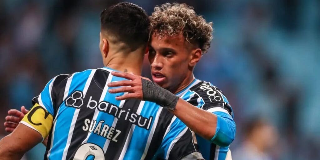 Luis Suárez abraça João Bitello em campo pelo Grêmio